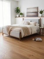 Lit double TOCO Meubles Flora avec tête de lit rembourrée grise et structure en bois dans une chambre moderne