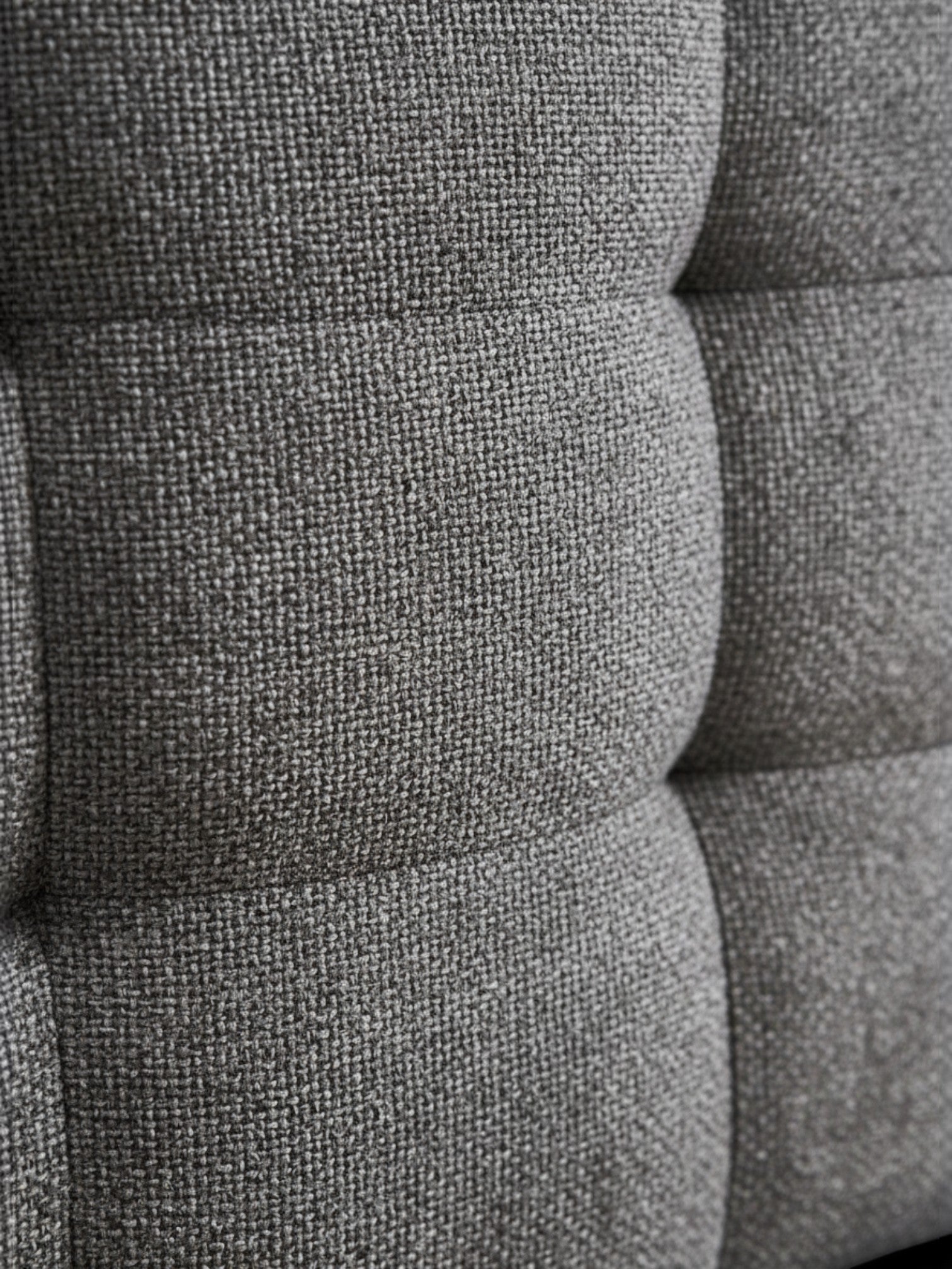 Gros plan sur le tissu bouclé gris texturé du lit Guilia de TOCO Meubles avec ses coutures raffinées