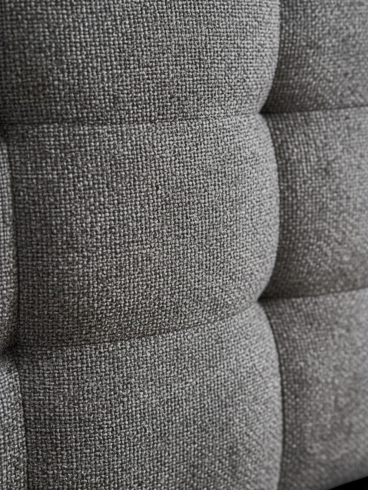 Gros plan sur le tissu bouclé gris texturé du lit Guilia de TOCO Meubles avec ses coutures raffinées