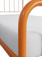 Gros plan sur la structure en métal orange du lit Simple Daisy de TOCO Meubles avec matelas blanc