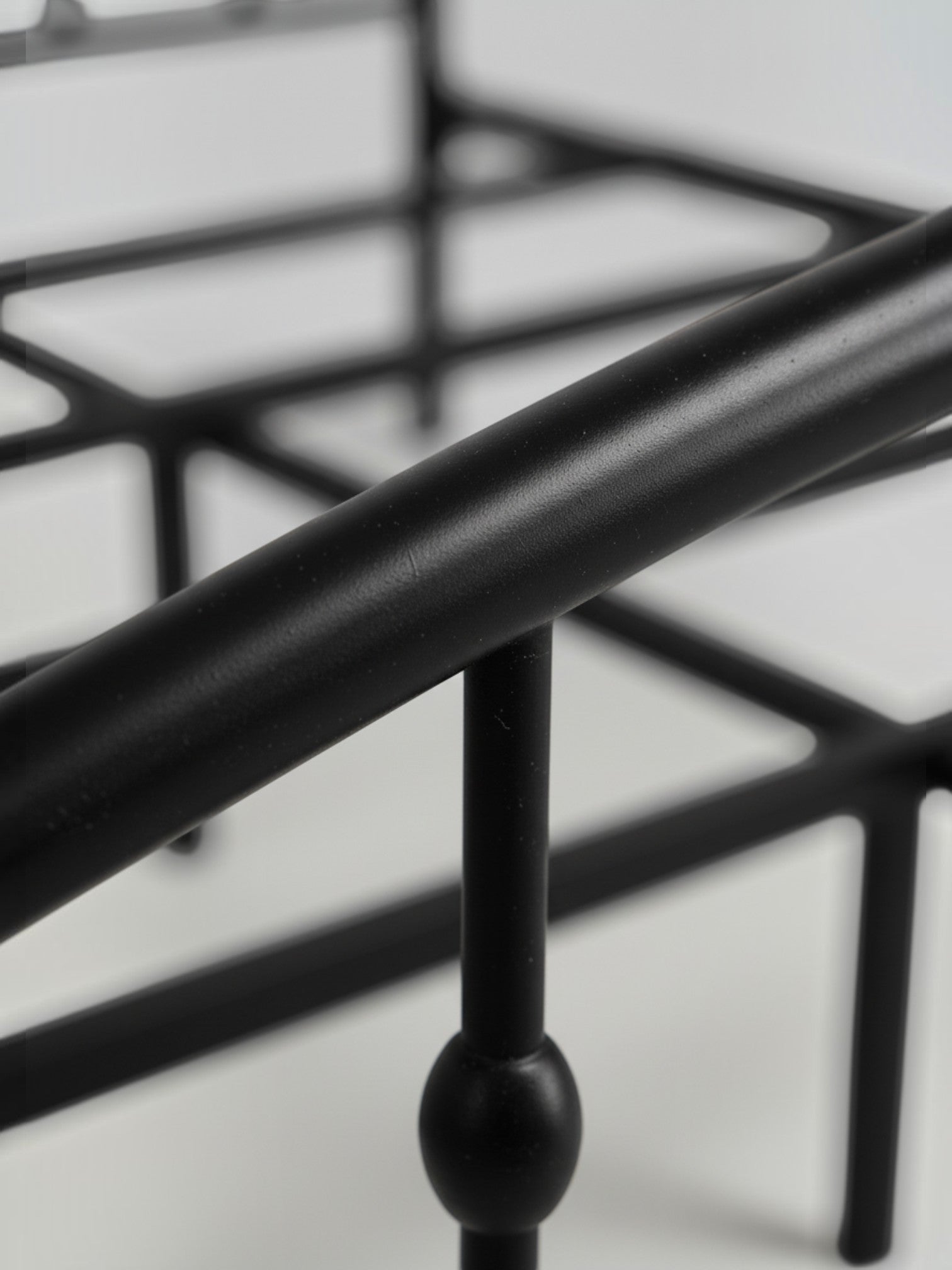 Gros plan sur la structure en acier noir du lit Nina de TOCO Meubles au design minimaliste et contemporain.