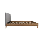 TOCO Meubles Lit Nova plateforme bas en bois brun avec tête de lit rembourrée en tissu gris.