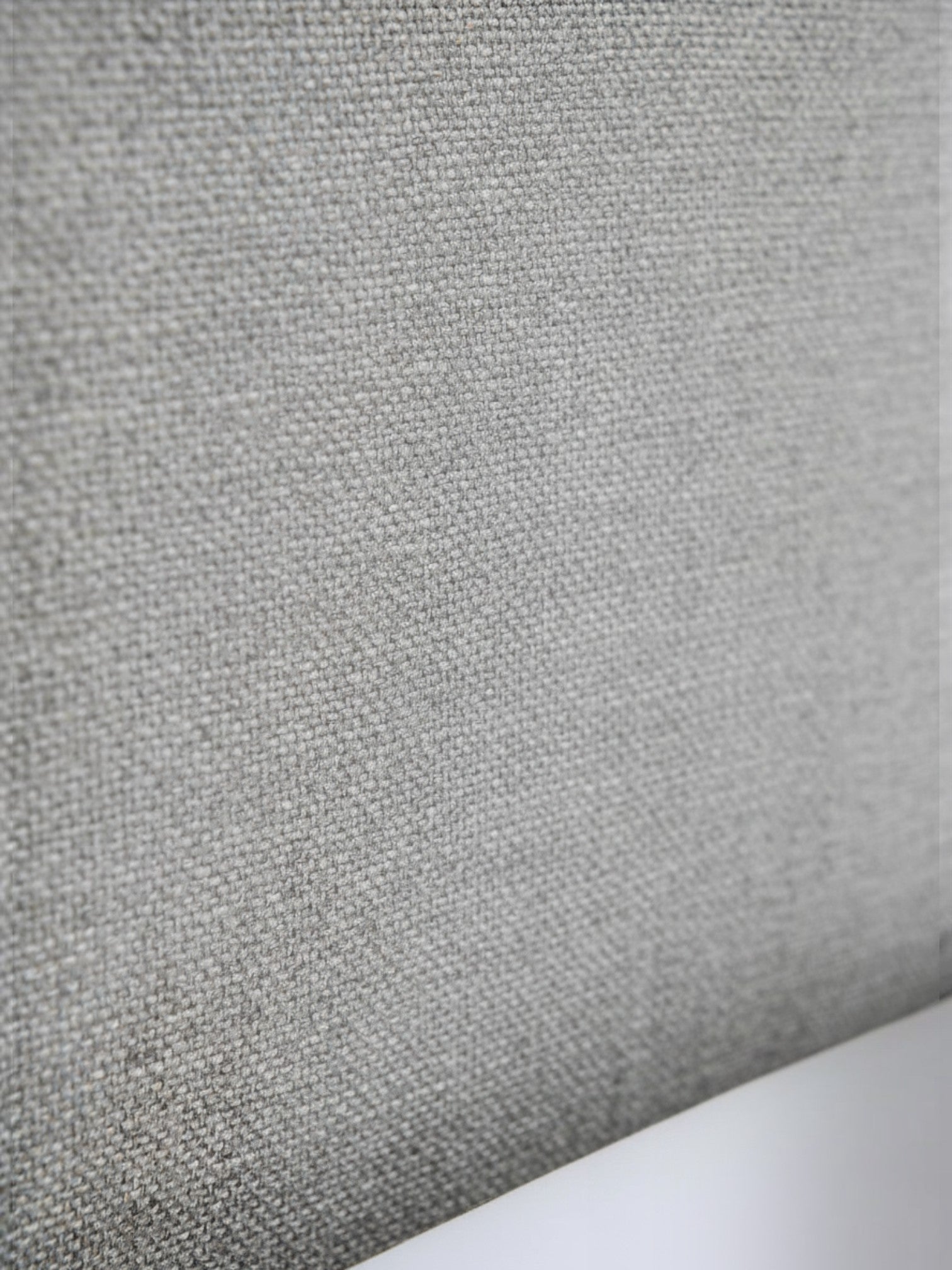 Gros plan sur le tissu gris texturé de la tête de lit du grand lit Nova par TOCO Meubles