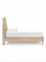 Lit TOCO Meubles Olive en bois clair avec tête de lit en cannage beige et un oreiller blanc.