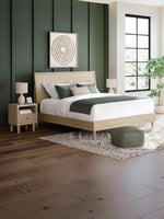 Très grand lit TOCO Meubles Olive en bois clair avec tête de lit texturée effet canne dans une chambre moderne