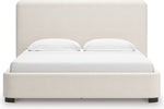 Lit Paloma TOCO Meubles grand format en tissu bouclé crème avec tête de lit enveloppante et pieds discrets.