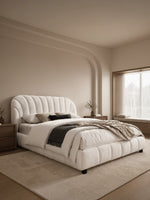 Lit plateforme TOCO Meubles Perla blanc en tissu bouclé avec tête de lit arquée capitonnée et pieds en acier noir.