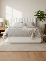 Lit plateforme queen TOCO Meubles beige avec tête de lit capitonnée verticale dans une chambre moderne et lumineuse