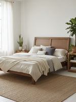 Très grand lit plateforme TOCO Meubles Antoine en bois brun clair avec tête de lit style traîneau dans une chambre