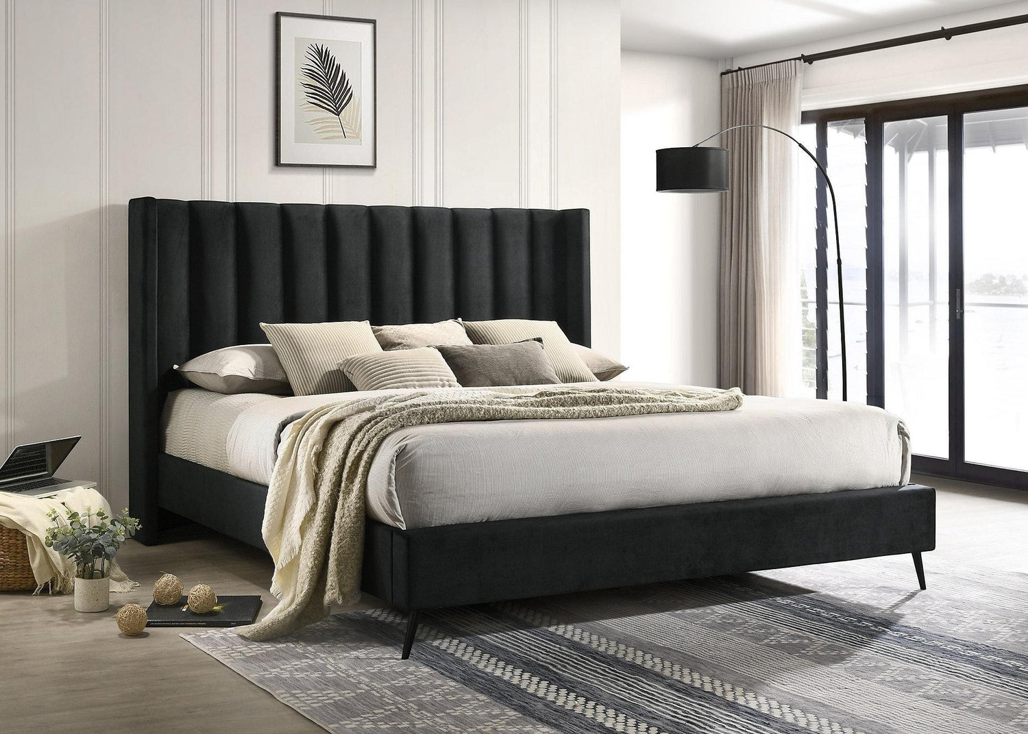 Lit plateforme noir en velours TOCO Meubles avec tête de lit capitonnée verticale et pieds en métal.