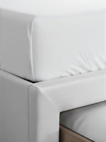 Gros plan sur le cadre de lit beige TOCO Meubles Zoey avec revêtement en tissu texturé et structure robuste