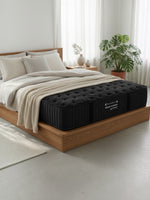 Matelas Dream Shadow HD noir ferme de TOCO Meubles sur un lit plateforme en bois dans une chambre lumineuse et moderne