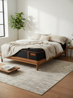 Matelas hybride TOCO Meubles Copper Sleep TT noir avec ressorts ensachés dans une chambre moderne et lumineuse