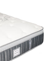 Matelas TOCO Meubles Optima avec tissu matelassé blanc, bordures grises et système de ressorts ensachés respirant.