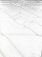 Gros plan sur le tissu rafraîchissant blanc et beige du matelas Ultra Medium de TOCO Meubles avec coutures matelassées