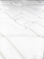Gros plan sur le tissu rafraîchissant blanc et beige du matelas Ultra Medium de TOCO Meubles avec coutures matelassées