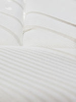 Gros plan sur le tissu matelassé blanc et respirant du matelas Ultra Plush de TOCO Meubles