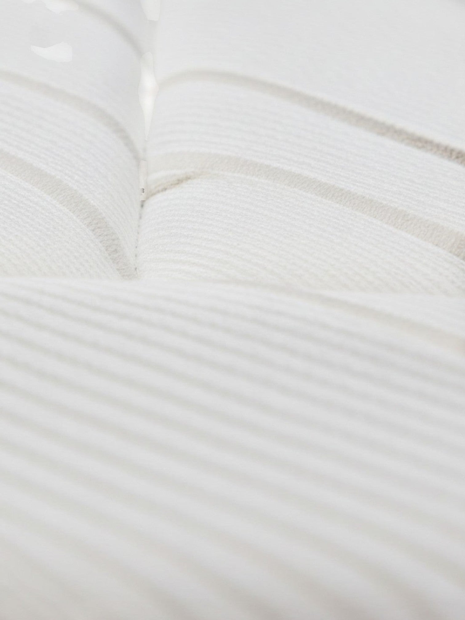Gros plan sur le tissu matelassé blanc et respirant du matelas Ultra Plush de TOCO Meubles