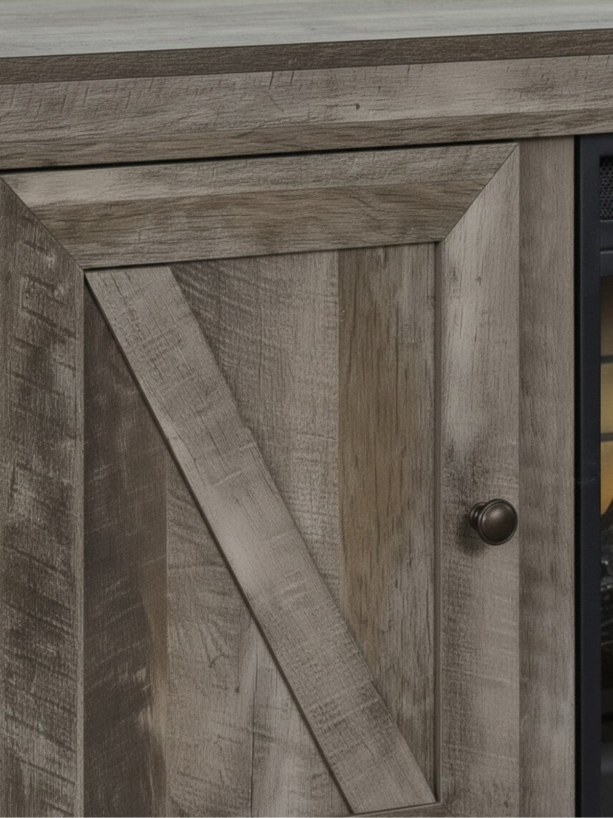 Gros plan sur la porte de style grange en bois gris texturé du meuble télé TOCO Meubles avec foyer