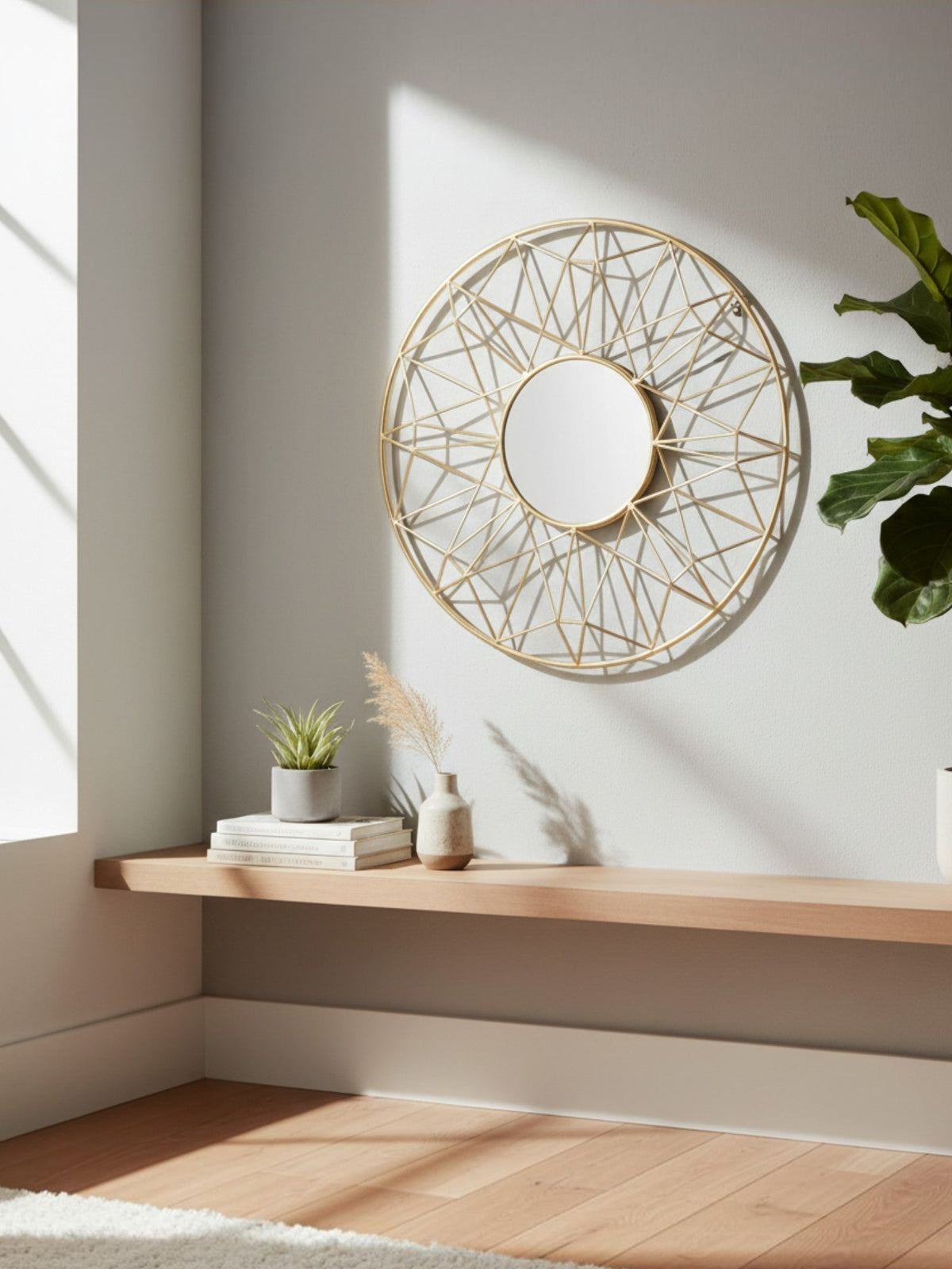 Miroir mural rond TOCO Meubles Horus avec cadre métallique doré géométrique inspiré du soleil sur un mur clair