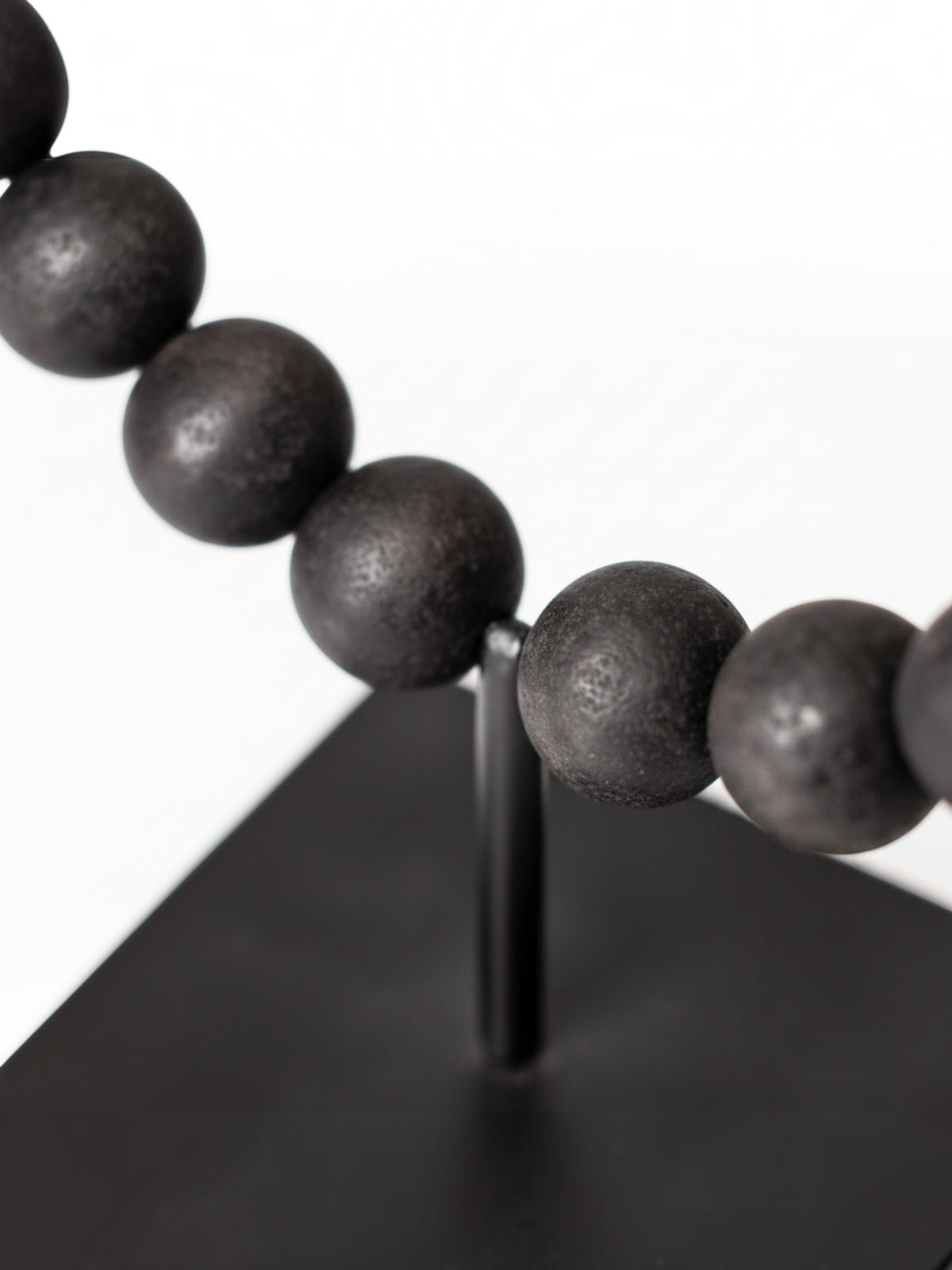 Objet décoratif TOCO Meubles Tulane, sphère brisée composée de perles noires mates sur un support métallique noir.