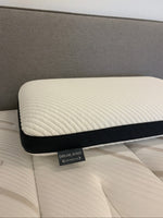 Oreiller ergonomique TOCO Meubles Dreamwave blanc avec bordure noire respirante posé sur un matelas