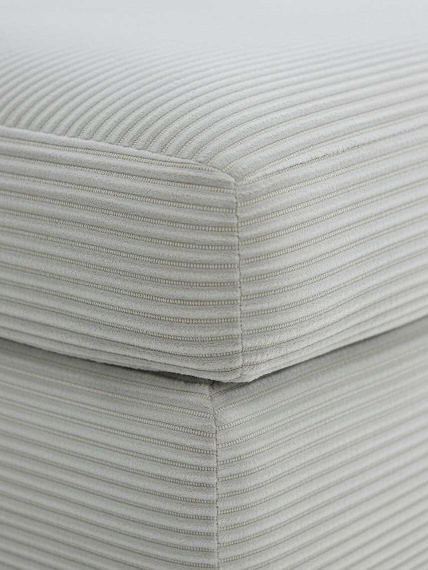 Gros plan sur le tissu texturé gris clair à rayures verticales de l'ottoman Aldo de TOCO Meubles