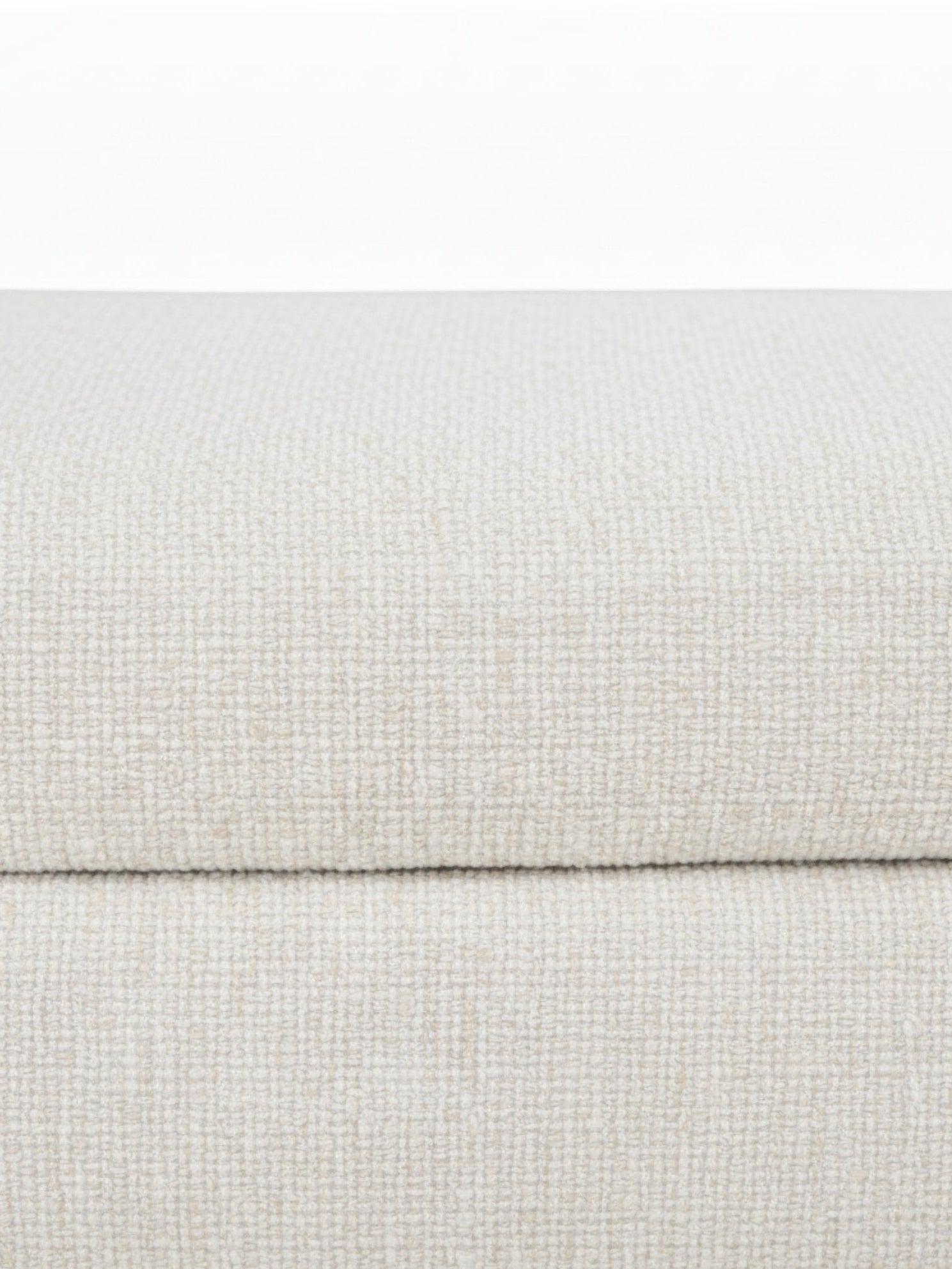 Gros plan sur la texture en tissu beige clair du pouf Ottoman Figaro de la marque TOCO Meubles