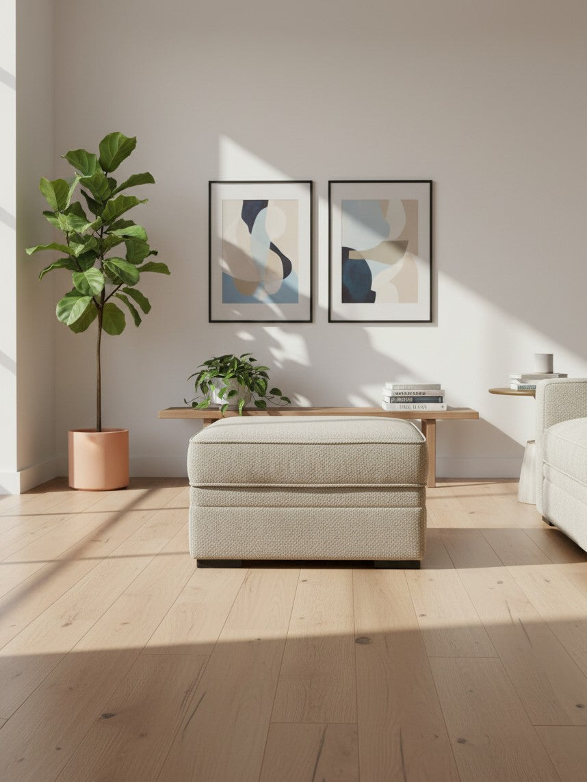 Ottoman Kael beige avec rangement de TOCO Meubles dans un salon lumineux avec plante et cadres muraux