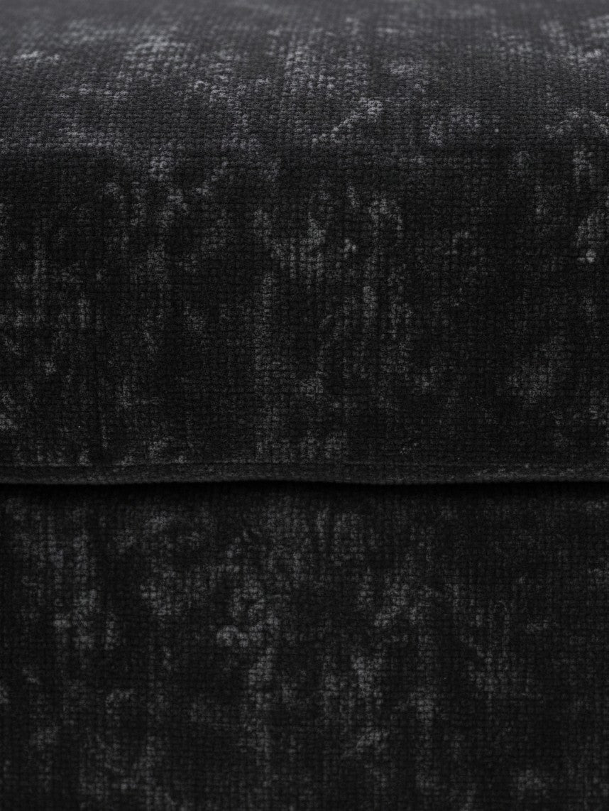 Gros plan sur le tissu texturé noir de l'ottoman Mistral par TOCO Meubles