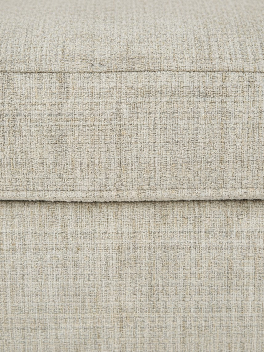 Gros plan sur le tissu texturé beige clair de l'ottoman Moka de TOCO Meubles avec coutures détaillées
