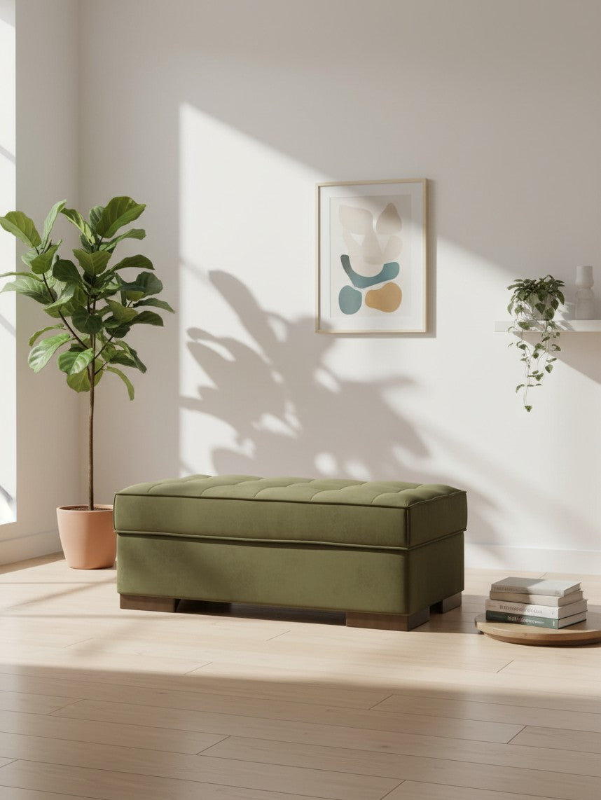 Ottoman Nino TOCO Meubles rectangulaire en velours olive capitonné dans un salon lumineux avec plante et cadre