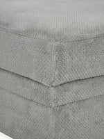 Gros plan sur le tissu texturé gris ciment de l'ottoman Ugo de TOCO Meubles
