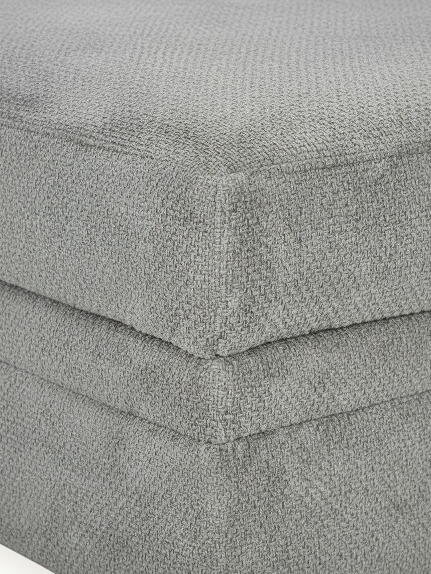 Gros plan sur le tissu texturé gris ciment de l'ottoman Ugo de TOCO Meubles