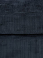 Gros plan sur le tissu en velours côtelé bleu marine de l'ottoman Toscana de TOCO Meubles
