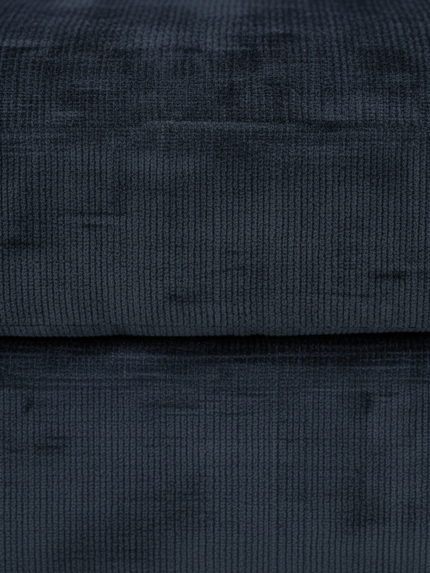 Gros plan sur le tissu en velours côtelé bleu marine de l'ottoman Toscana de TOCO Meubles