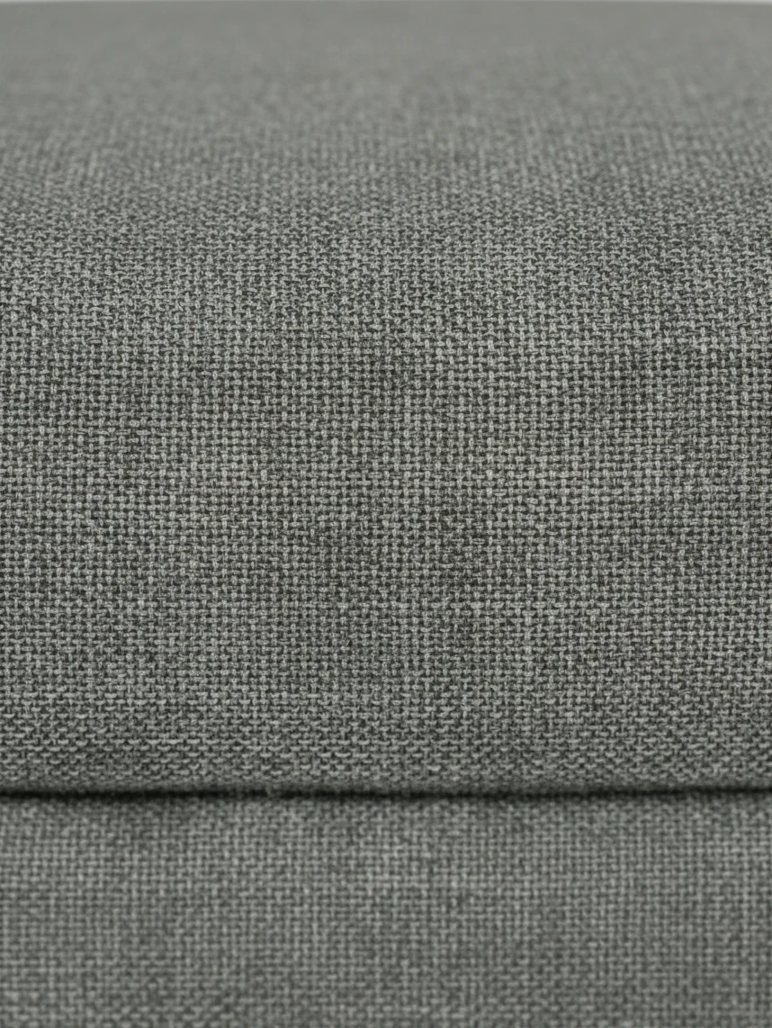 Gros plan sur le tissu texturé gris anthracite de l'ottoman Zela par TOCO Meubles