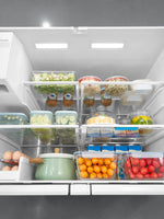 Intérieur du réfrigérateur TOCO Meubles Midea avec tablettes modulables remplies d'aliments frais et organisés