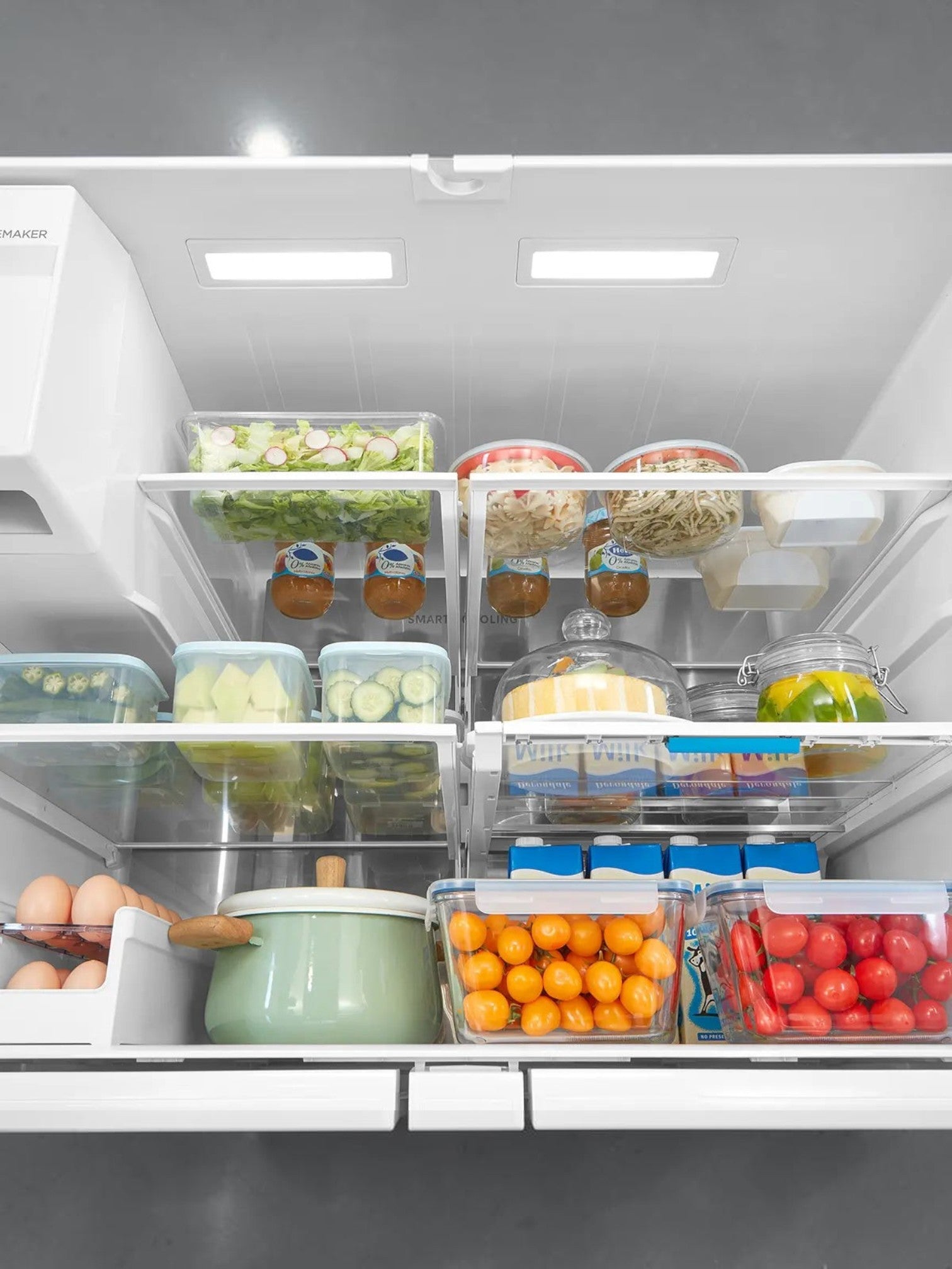 Intérieur du réfrigérateur TOCO Meubles Midea avec tablettes modulables remplies d'aliments frais et organisés