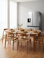 Réfrigérateur MIDEA à portes françaises en acier inoxydable dans une salle à manger moderne avec table en bois
