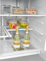 Intérieur du réfrigérateur MIDEA chez TOCO Meubles avec tablettes modulables Infinite Shelf et bouteilles de vin