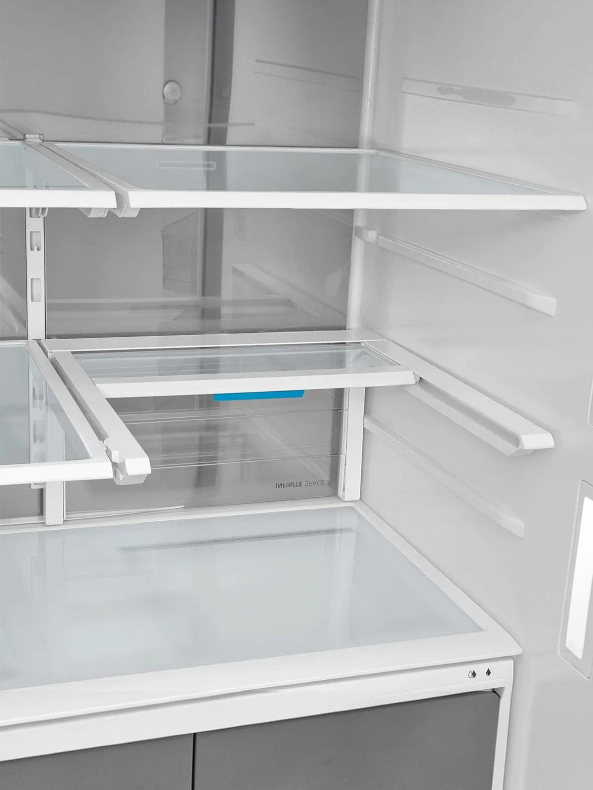 Intérieur du réfrigérateur MIDEA chez TOCO Meubles avec tablettes modulables Infinite Shelf et design spacieux
