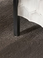 Pied en métal noir du meuble d'appoint 2 portes Savannah de TOCO Meubles posé sur un tapis gris texturé