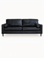 Sofa Bryce de TOCO Meubles en cuir noir avec coussins cylindriques et pieds fuselés