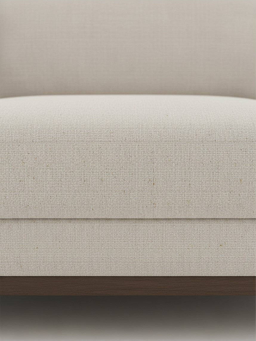 Gros plan sur le tissu beige texturé du sofa sectionnel Calvi de TOCO Meubles avec base en bois foncé