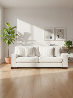 Sofa Figaro TOCO Meubles blanc cassé en tissu avec coussins rayés dans un salon lumineux et moderne