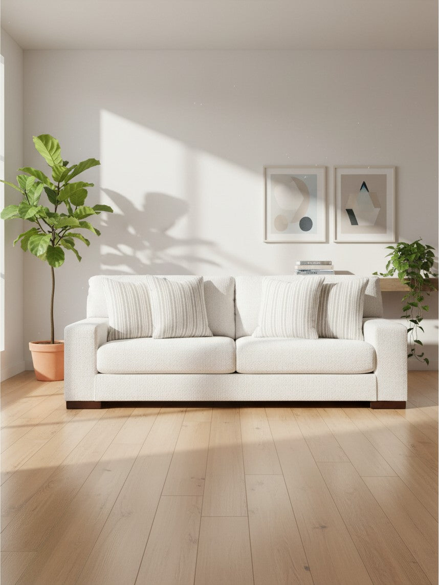 Sofa Figaro TOCO Meubles blanc cassé en tissu avec coussins rayés dans un salon lumineux et moderne