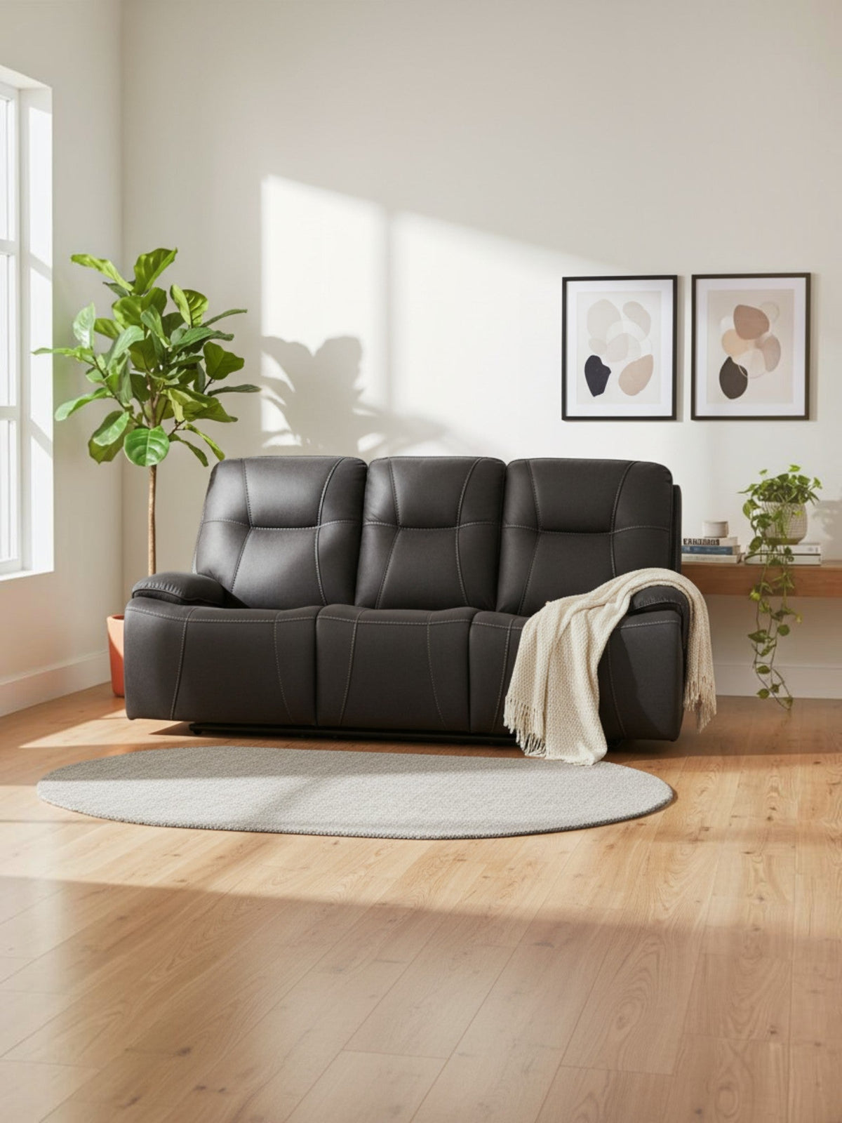 Sofa inclinable Elvis de TOCO Meubles en cuir gris foncé avec surpiqûres contrastantes dans un salon moderne