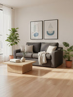 Sofa-lit Ayana de TOCO Meubles gris anthracite avec coussins et plaid dans un salon moderne et lumineux