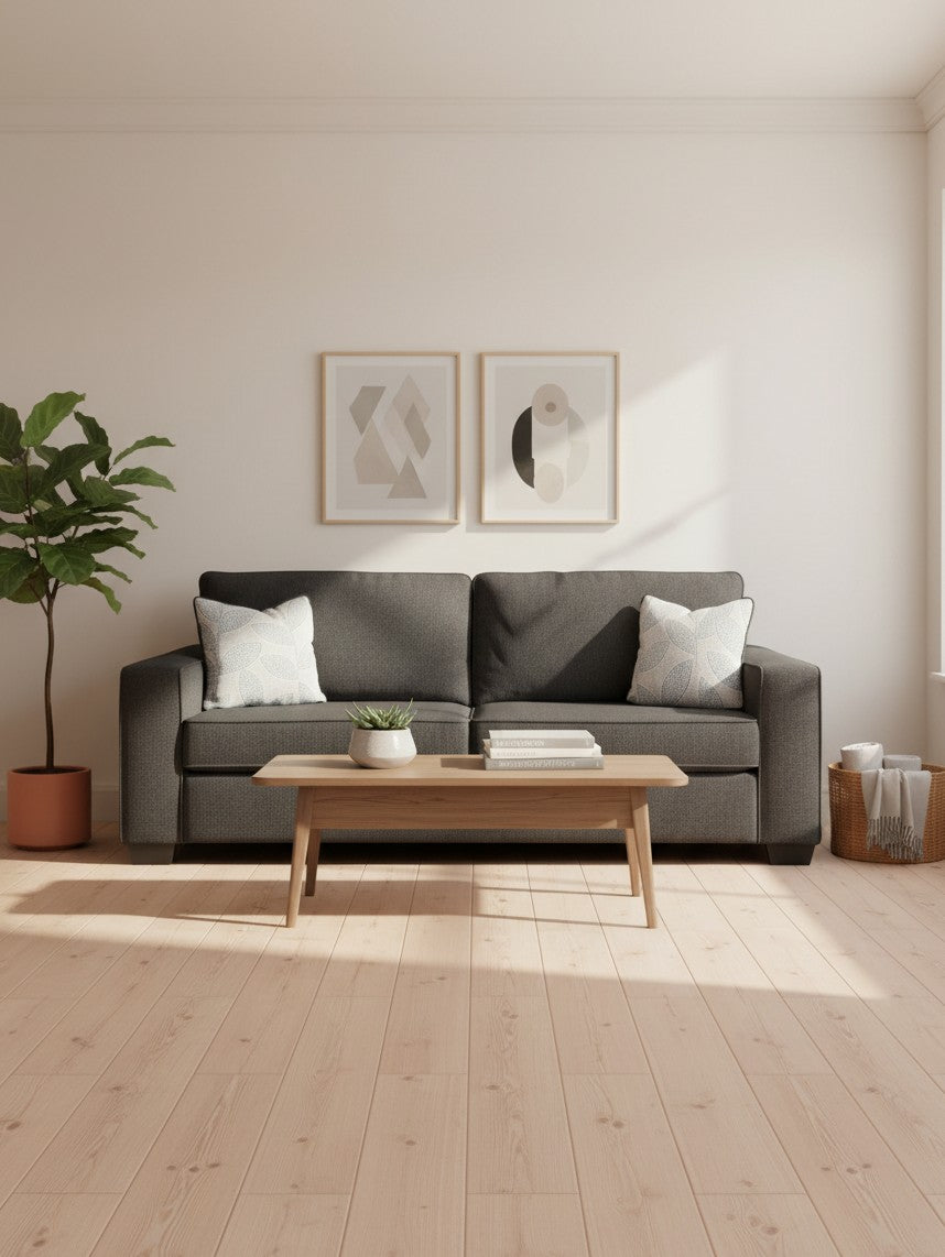 Sofa-lit Marcel gris foncé de TOCO Meubles avec coussins décoratifs dans un salon moderne et lumineux